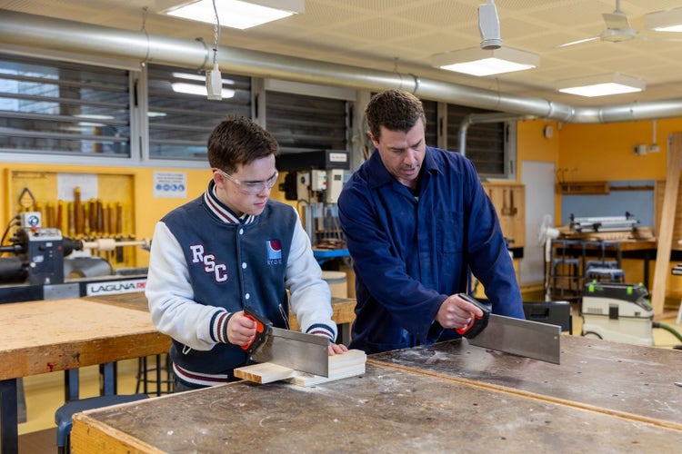 Teacher supporting student in industrial technology